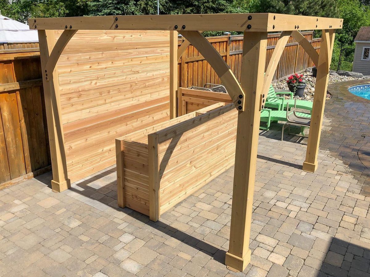 Wooden outdoor bar structure on a stone patio with a high wooden frame