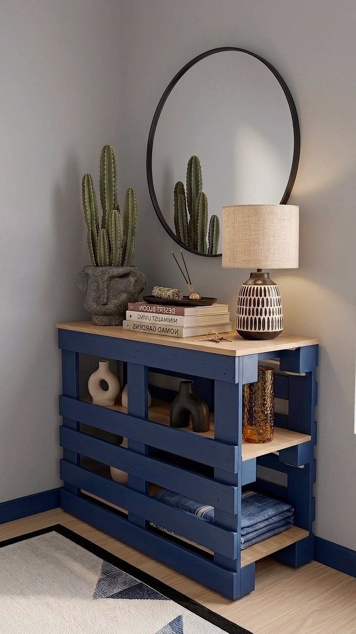 Blue painted pallet table with a wooden top, lamp, and cactus plant.