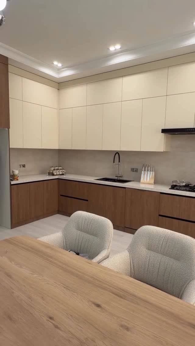 Two-tone kitchen cabinets with cream upper units and brown wood lower units.
