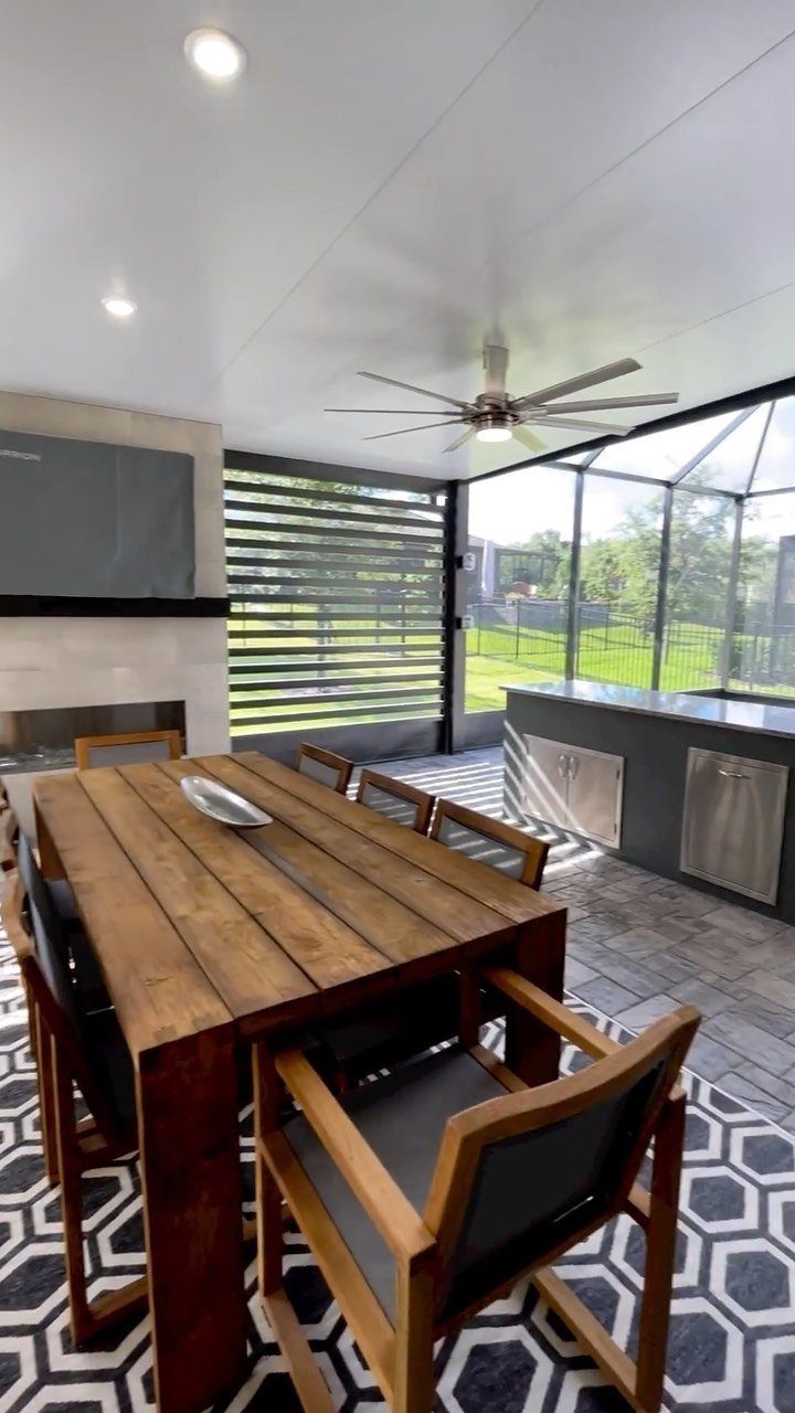 Covered outdoor patio with wooden dining table and built-in kitchen area