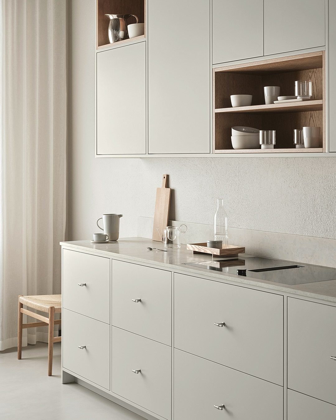 Light grey minimalist kitchen cabinets with clean lines and open wooden shelving.