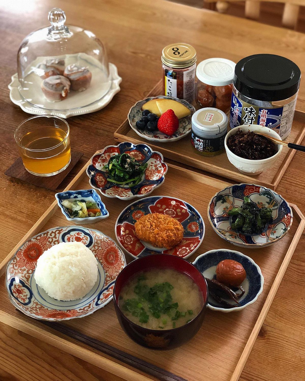Traditional Japanese meal with rice and soup in colorful ceramic tableware on wooden trays.