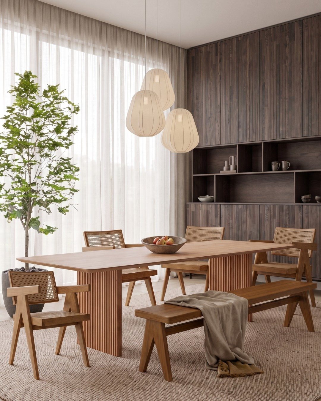 Minimalist dining room with light wood furniture, white pendant lights, and dark cabinetry.