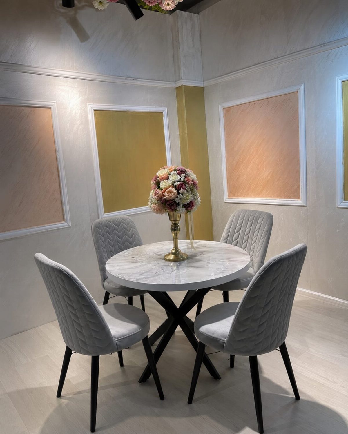 White marble round dining table with grey quilted chairs and floral centerpiece