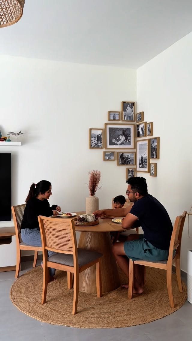 Family dining at a round wooden table placed on a circular jute rug.