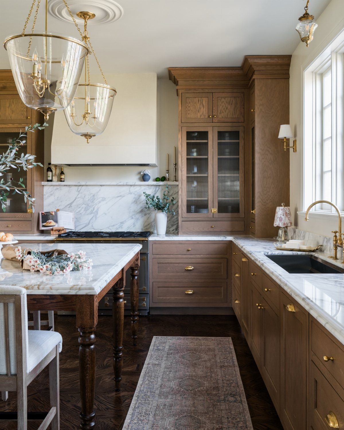 White marble countertops on a kitchen island and perimeter cabinets in a farmhouse kitchen.