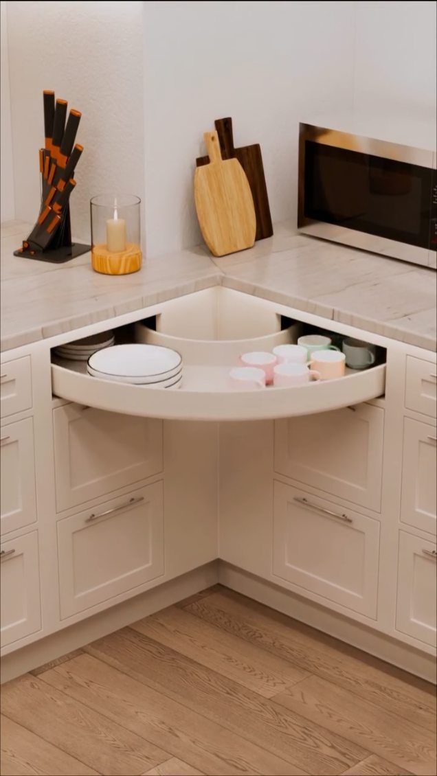 Curved swing-out corner cupboard shelf holding white plates and small colorful bowls.