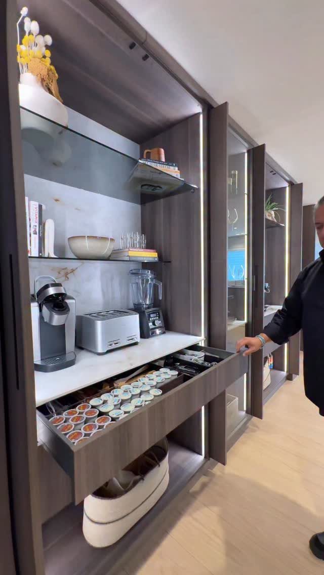 Modern built-in coffee station with coffee machine, toaster, and pod storage drawer.