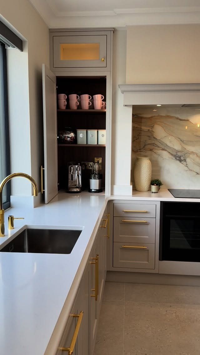 White kitchen countertop with a small sink and a built-in coffee station nook.