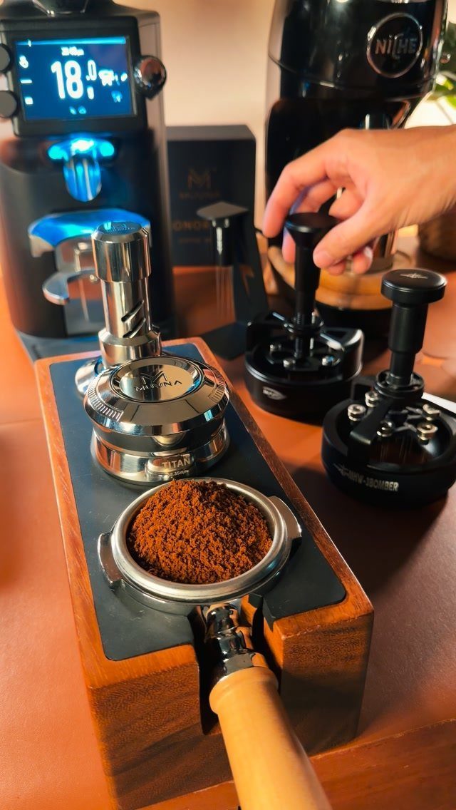 Espresso machine and wooden tamping station with ground coffee in a portafilter