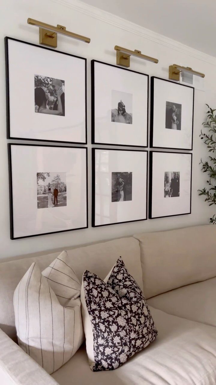 Six black-framed black and white photos arranged as a gallery wall above a sofa.