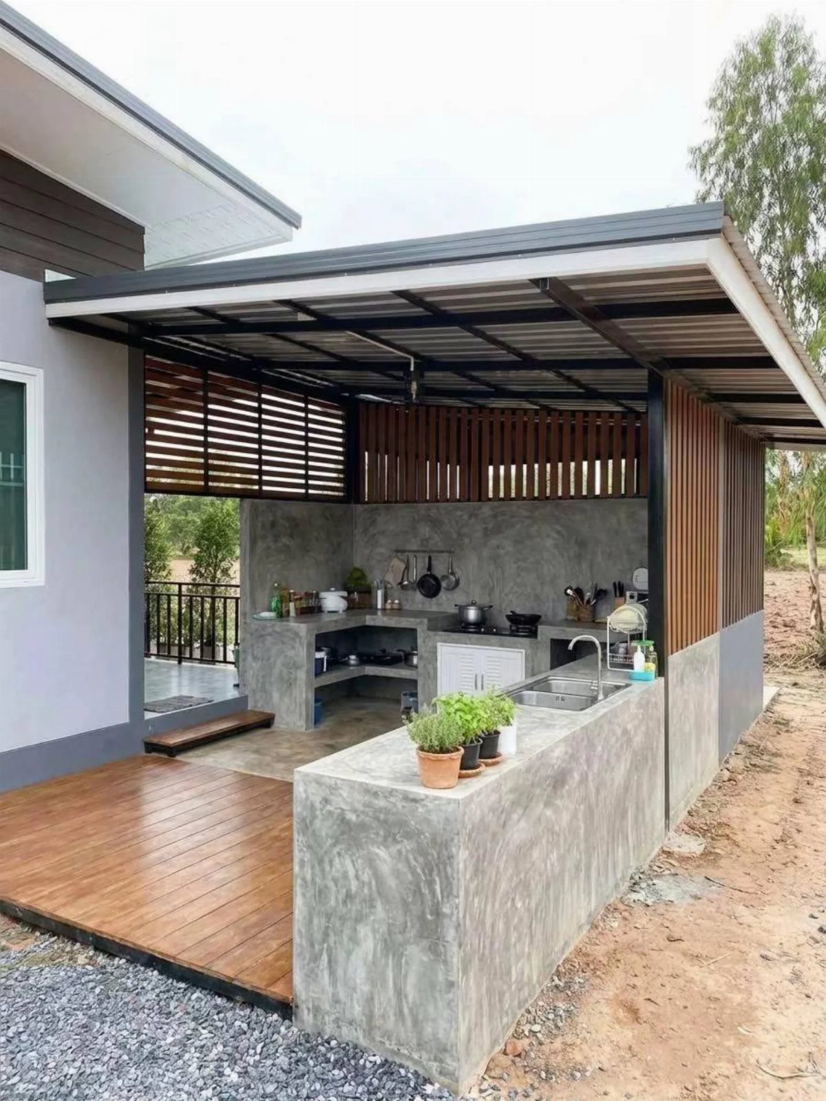 Outdoor kitchen with grey concrete countertops and a minimalist concrete slab backsplash.
