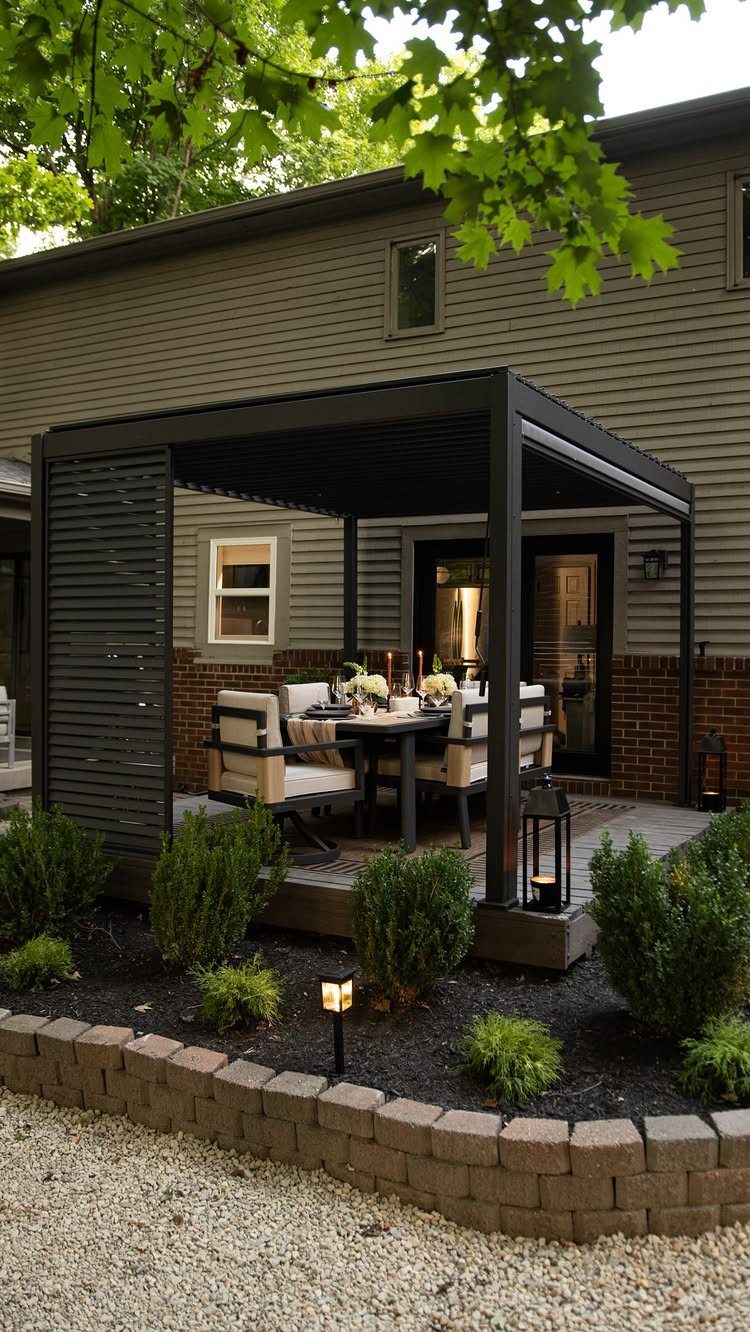 Outdoor dining table with beige chairs under a black metal pergola on a patio
