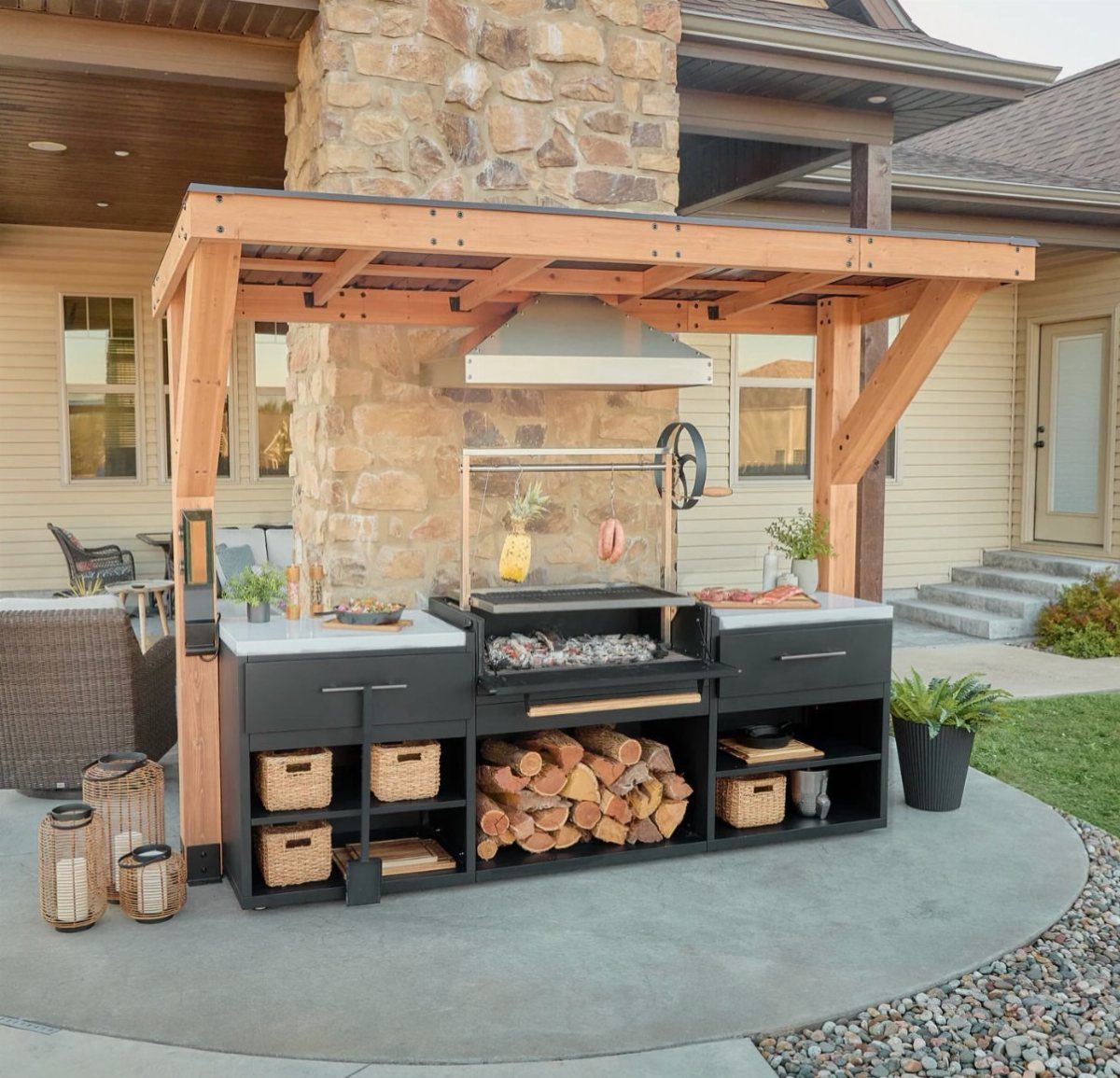 Modern outdoor kitchen with black cabinets, built-in grill, and wooden pergola structure.