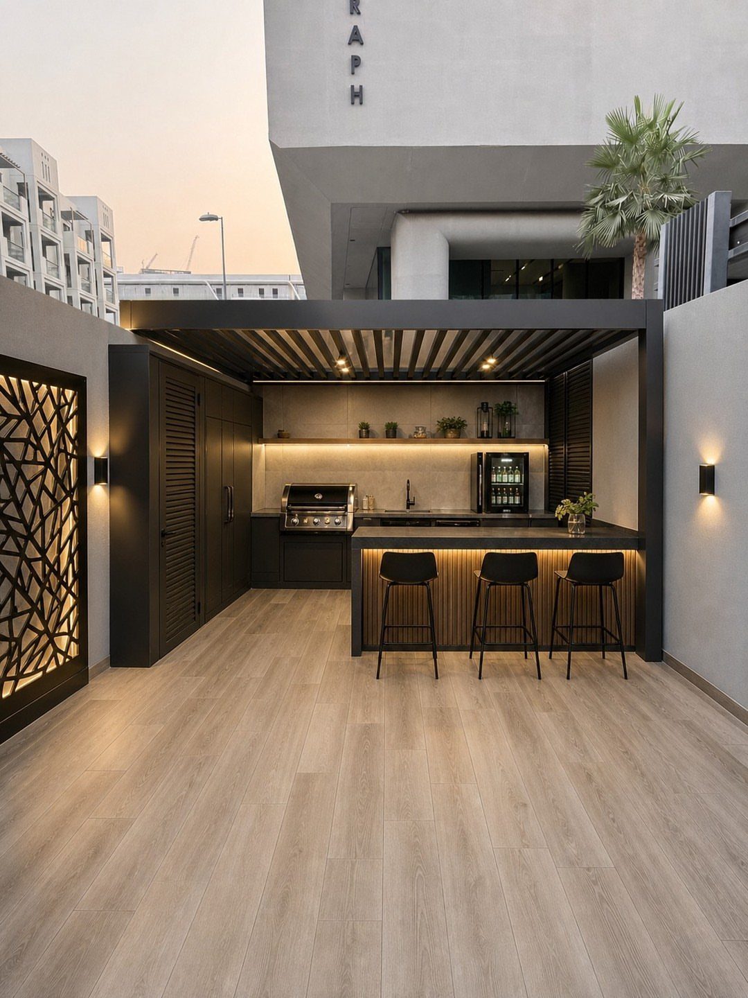 Modern outdoor kitchen with black cabinets, built-in grill, and wooden bar stools.