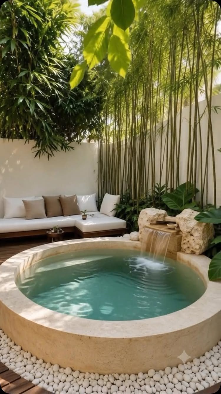 Circular stone plunge pool with a small waterfall and outdoor lounge seating.