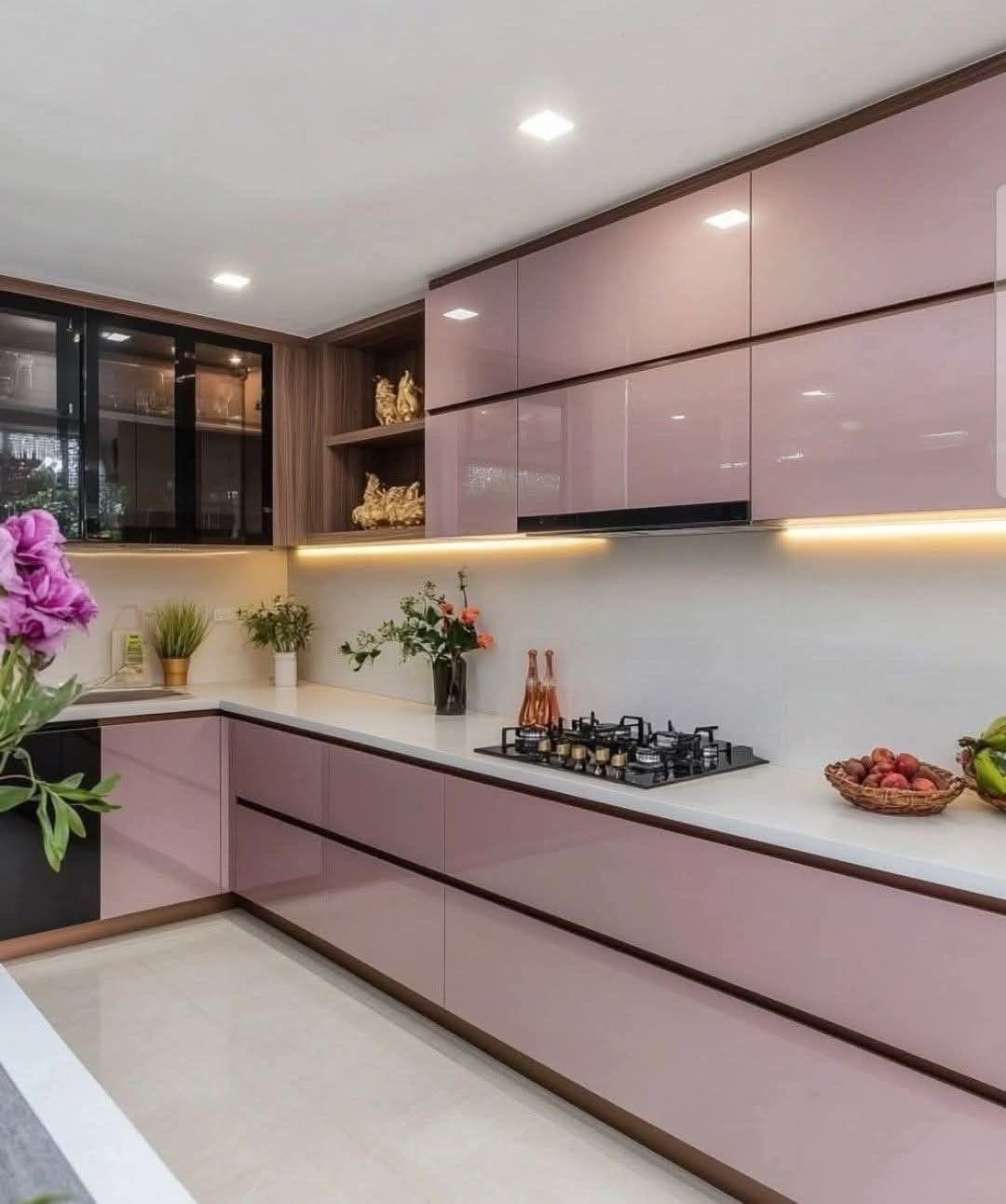 Modern L-shaped kitchen with glossy purple cabinets and white countertops and a stovetop